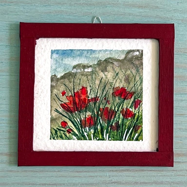 A watercolor mini painting depicting a field of poppies.